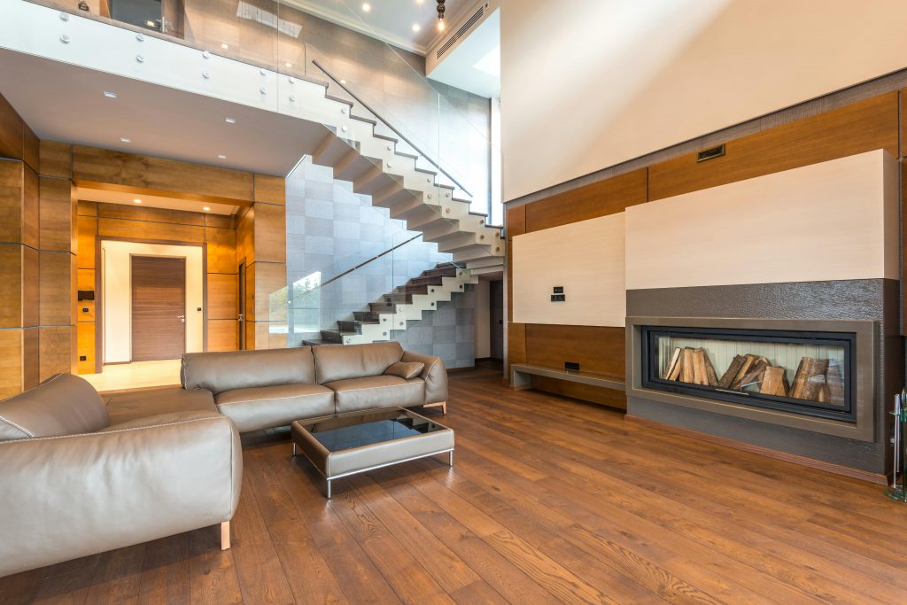 Spacious modern living room featuring a sleek fireplace and leather couches in a minimalist design.
